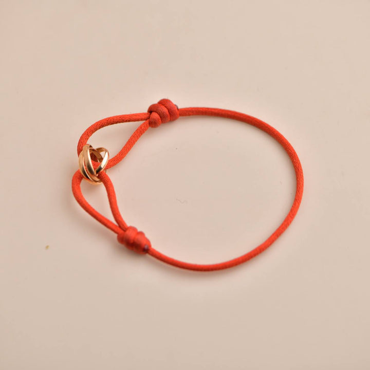 Authentic pre-owned Cartier Trinity 18K Rose Gold Bracelet with red silk cord