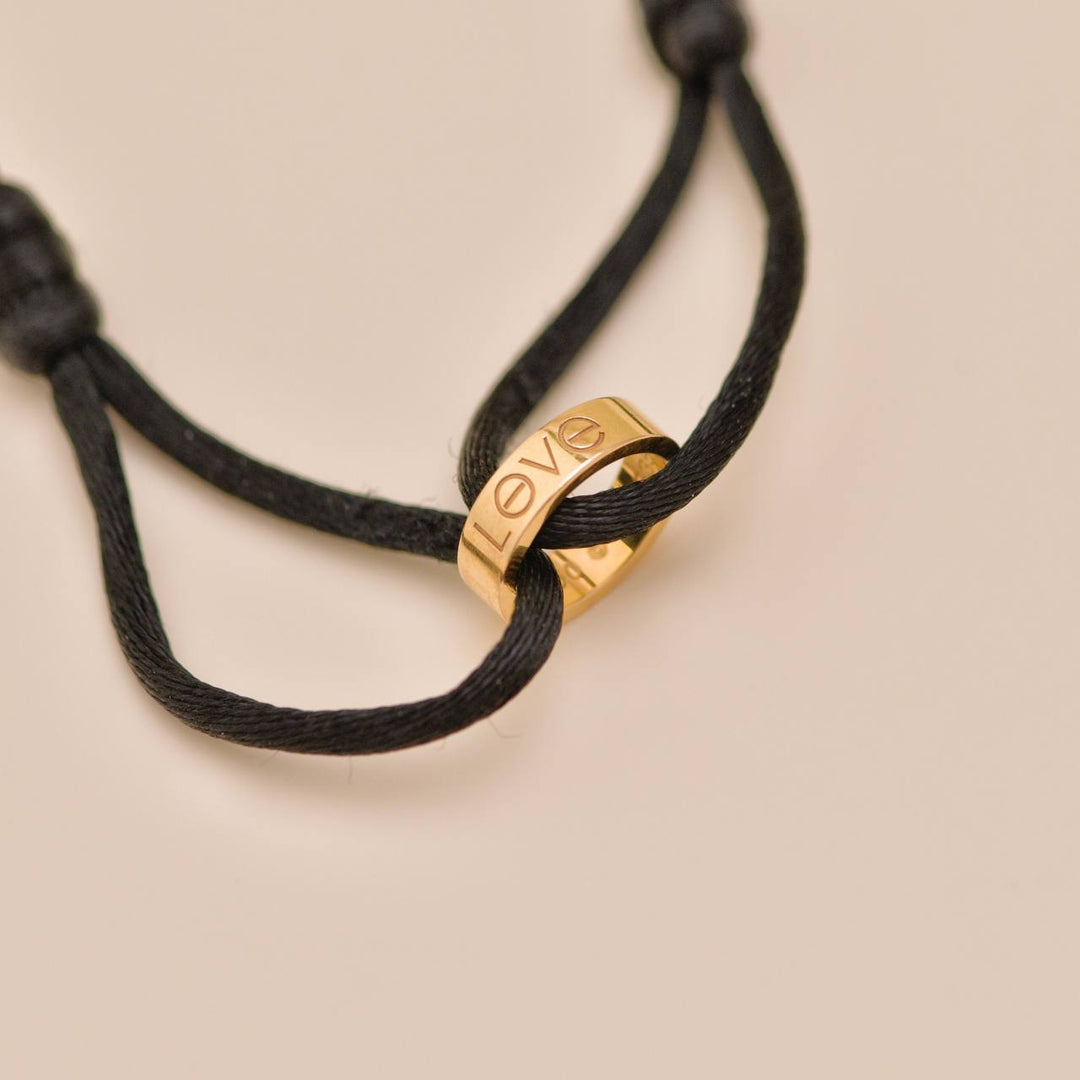 Authentic used full set Cartier Love Cord bracelet in 18K rose gold with black adjustable cord